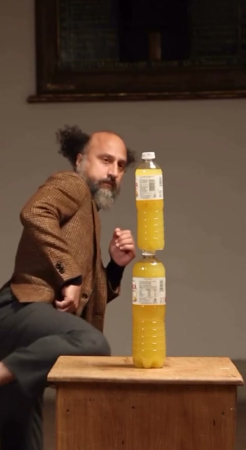 Performer preparing to kick stacked bottles