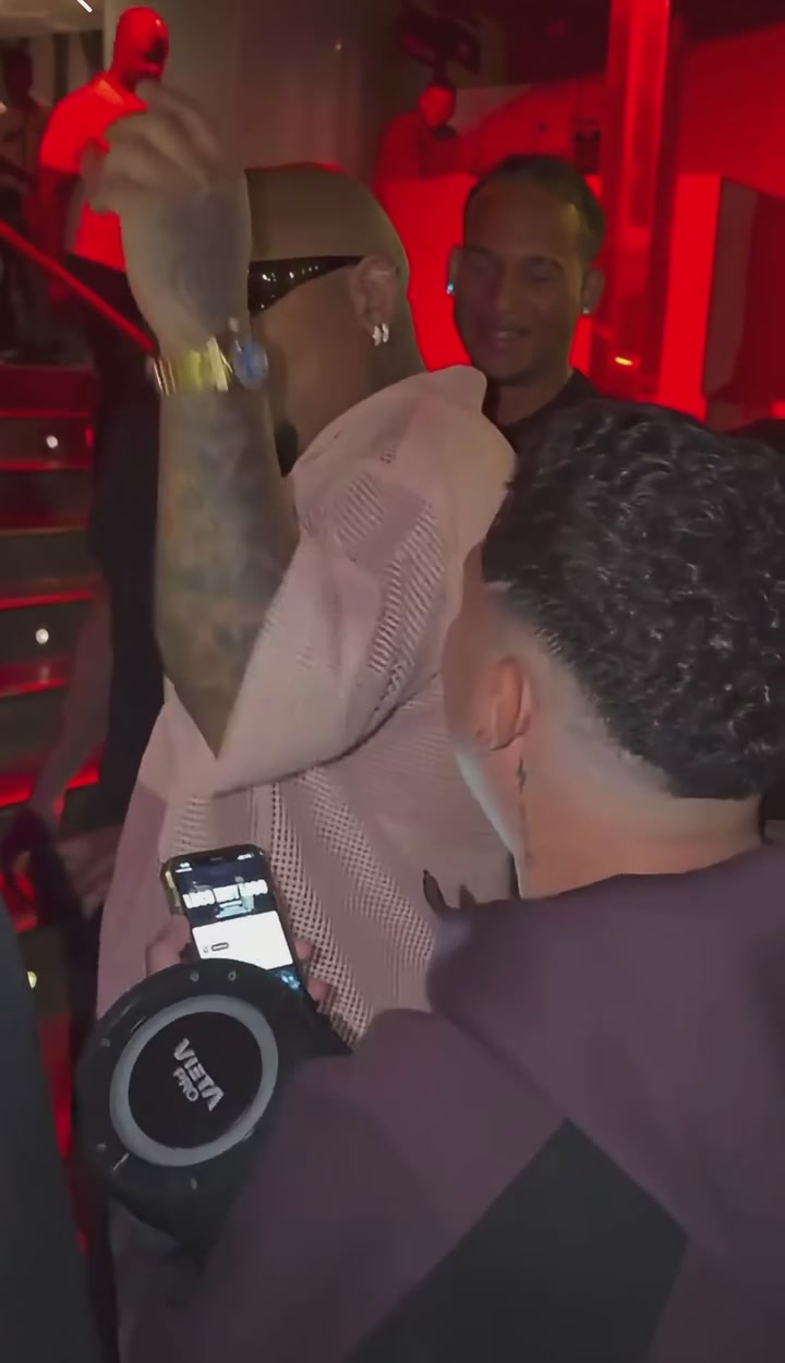Foreground person holding the portable speaker, whose appearance should stay unchanged