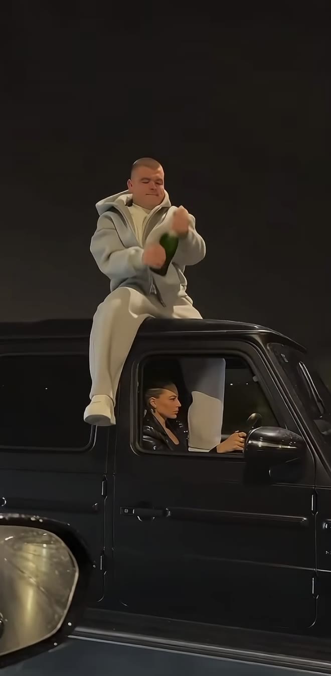 Champagne Shoot AI reference showing the rooftop performer and driver in a black SUV during a fictional nighttime celebration