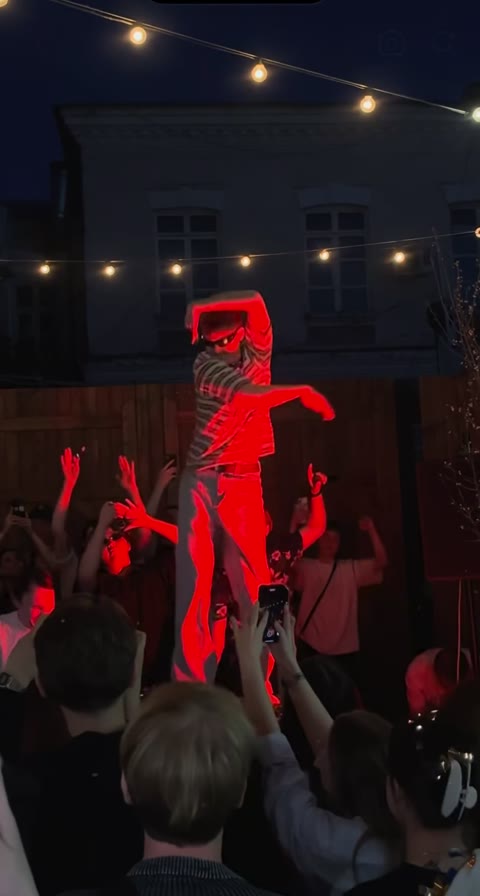 Late frame of the Cheba Man dance reference with spectators around the stage