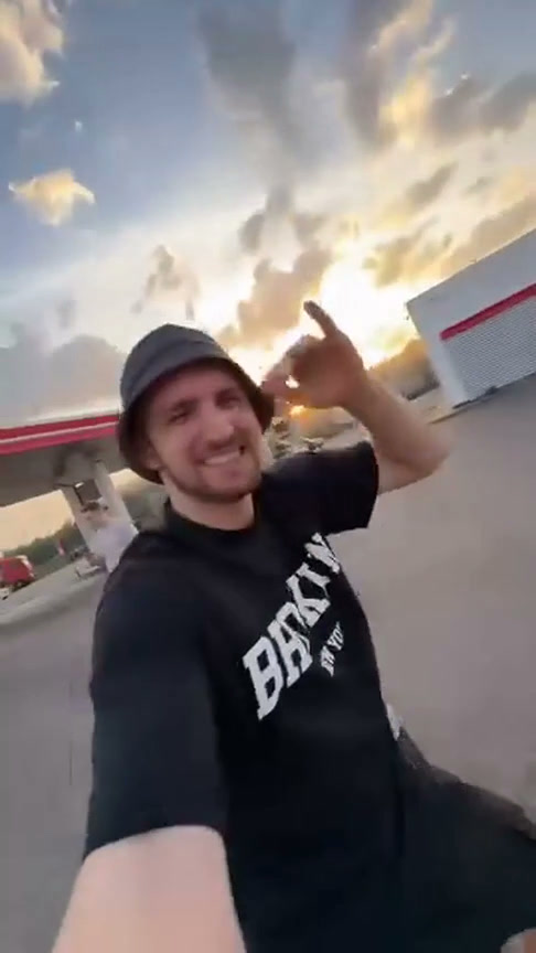 Selfie de la fuente: quien graba lleva camiseta oscura y sombrero de pescador