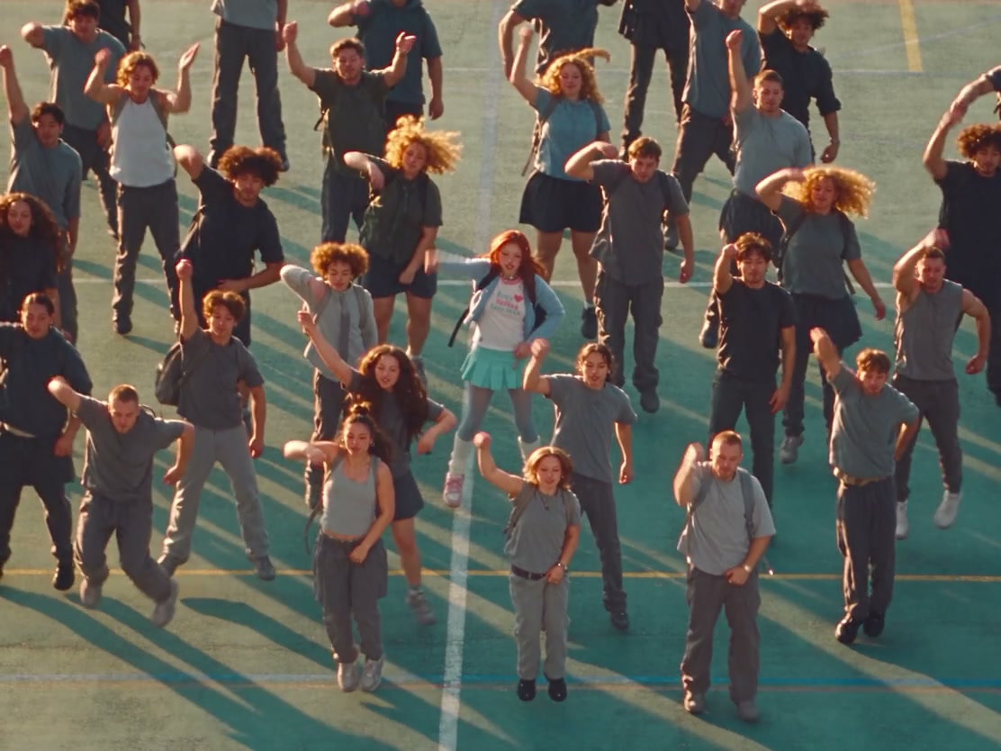 The front-center lead dancing with the synchronized playground ensemble