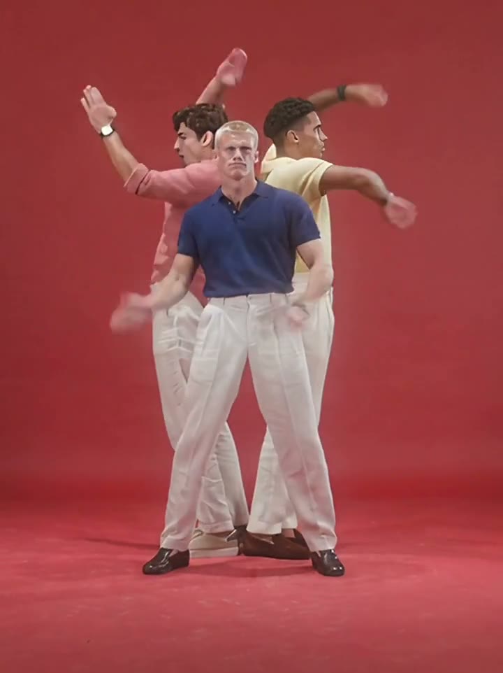 The centre lead standing between two supporting dancers in the red studio