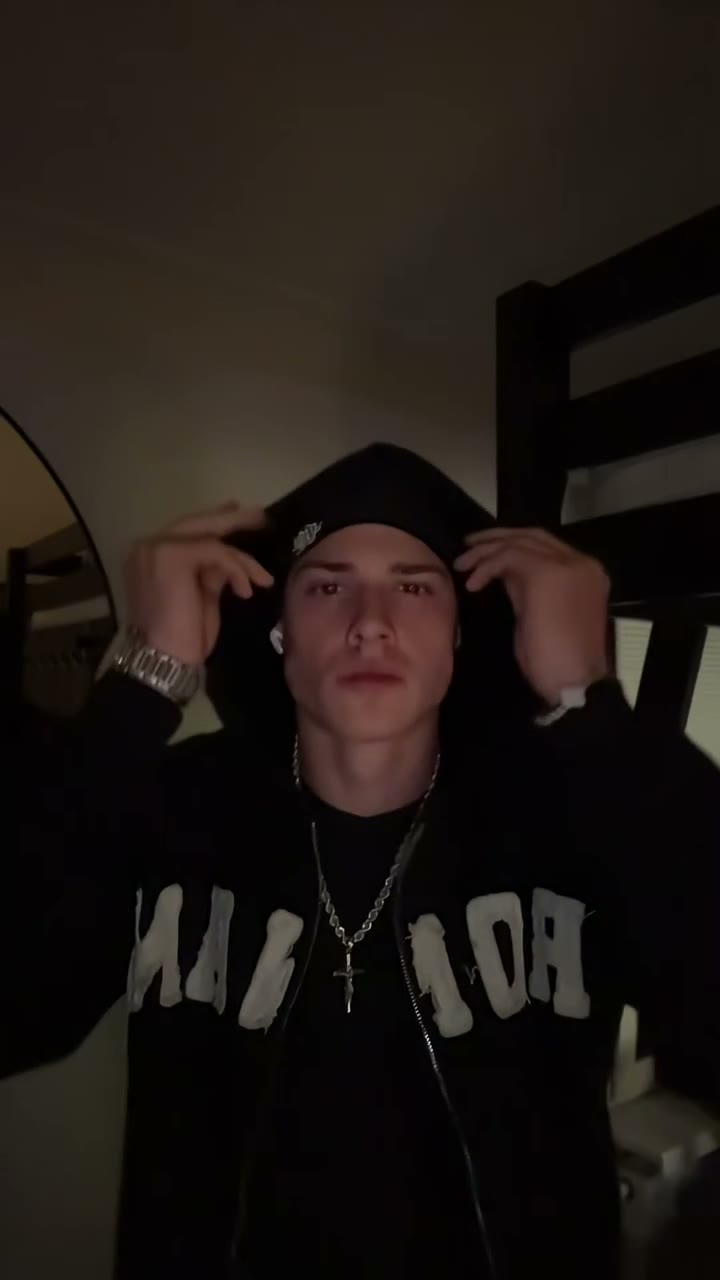 The hooded character looking toward the camera in a dark setting