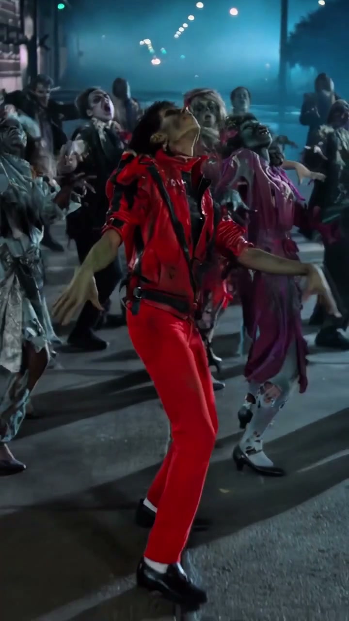 A center-front lead performing bent-knee steps and claw-like arm gestures with zombie dancers on a foggy blue night street
