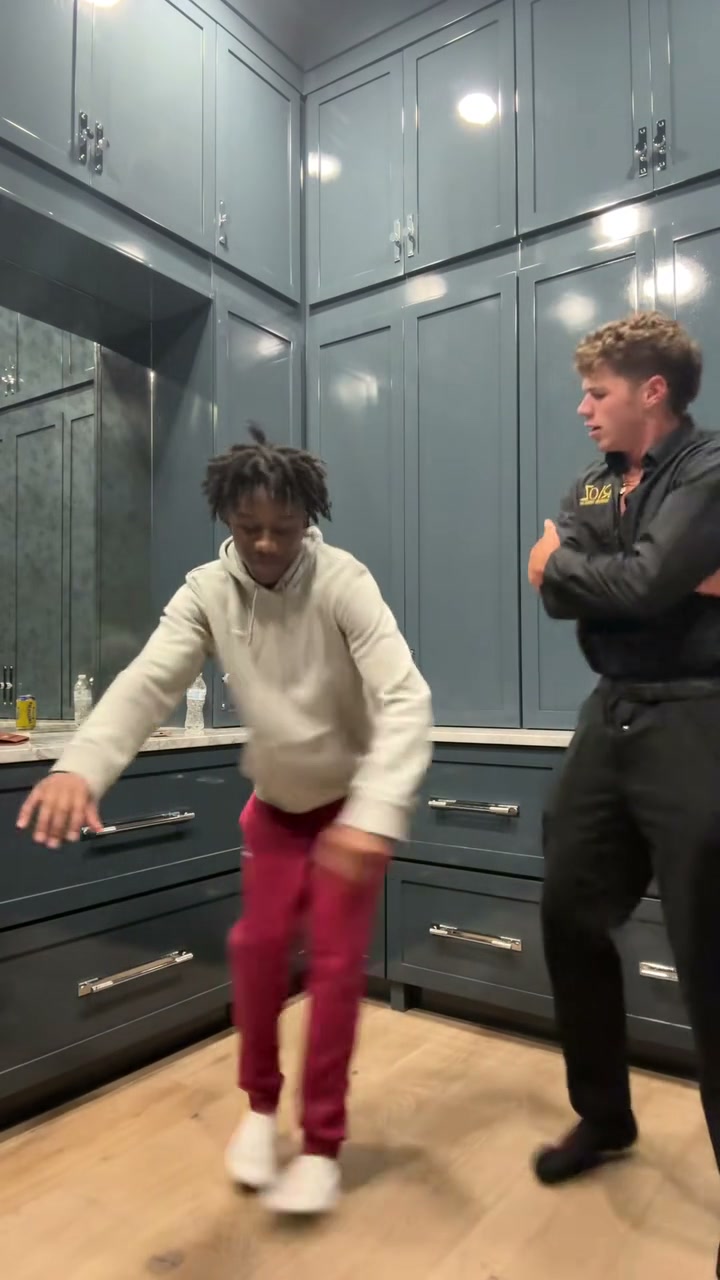 Original kitchen dance reference: two dancers in black and a light hoodie with red trousers take turns in front of a fixed camera